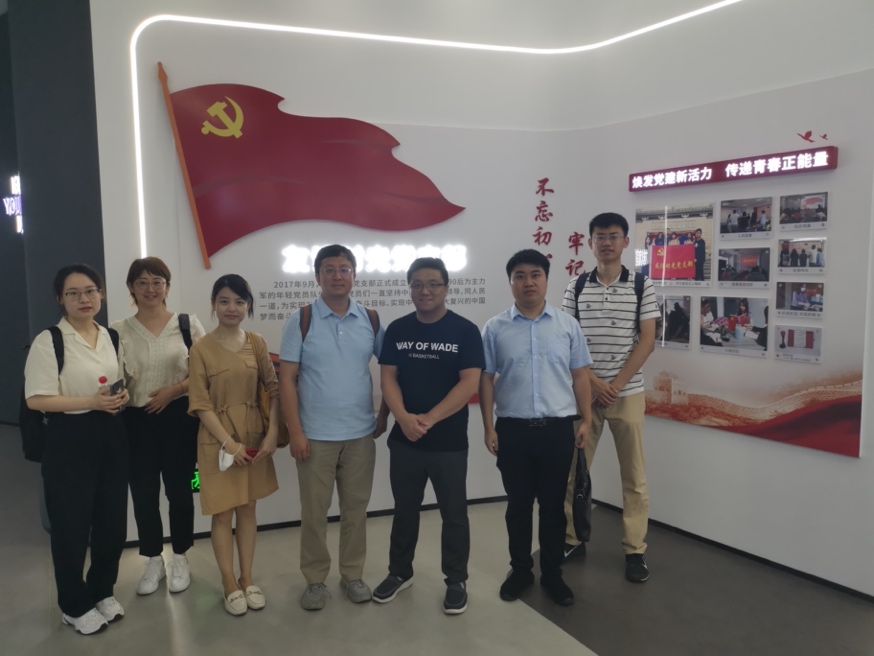 一群人站在画前合影低可信度描述已自动生成